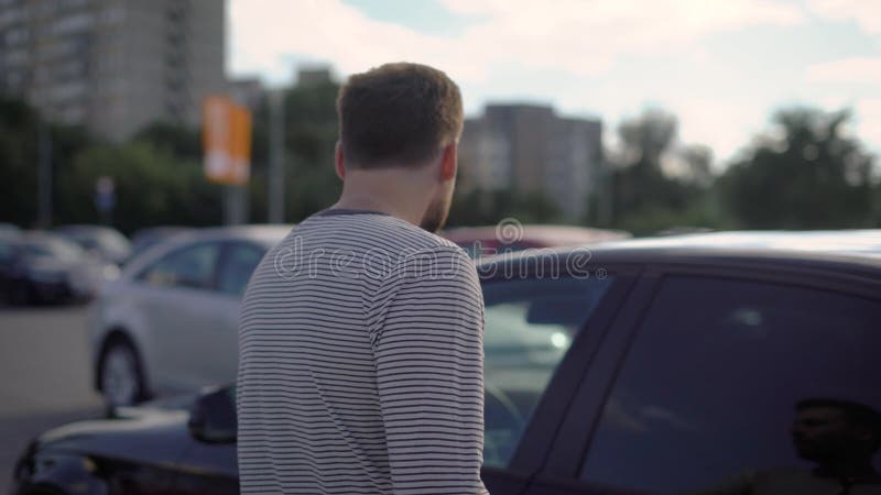 Επιχειρηματίας που περπατά στο αυτοκίνητό του στο χώρο στάθμευσης αργά μετά από την εργασία