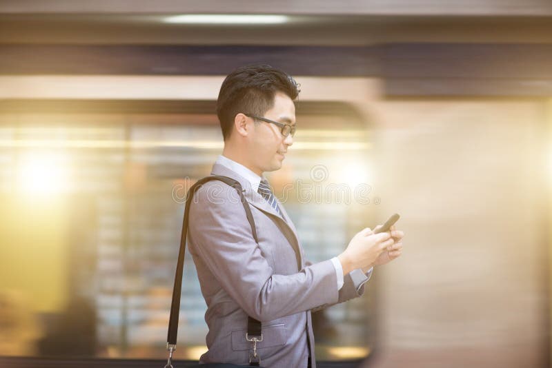 Επιχειρηματίας που χρησιμοποιεί το smartphone στο σταθμό μετρό στοκ φωτογραφίες με δικαίωμα ελεύθερης χρήσης Επιχειρηματίας που χρησιμοποιεί το smartphone στο σταθμό μετρό στοκ φωτογραφίες με δικαίωμα ελεύθερης χρήσης