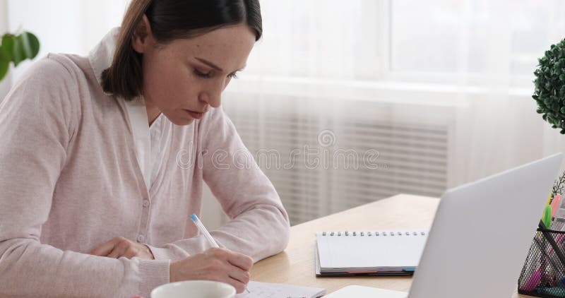 Επιχειρηματίας χρησιμοποιώντας το lap-top και παίρνοντας τις σημειώσεις στο γραφείο