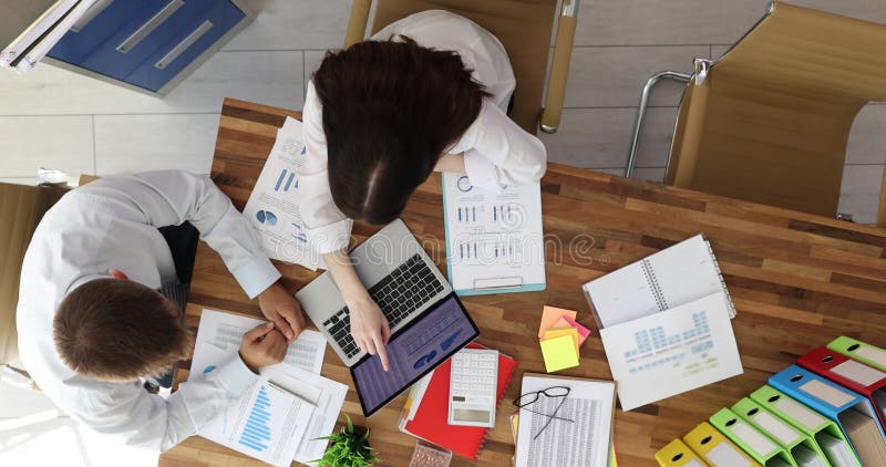 Επιχειρηματικοί συνεργάτες που ασχολούνται με την αναθεώρηση οικονομικών γραφημάτων σε φορητό υπολογιστή φιλμ μικρού μήκους