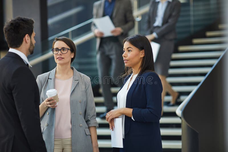 Επιχειρησιακοί συνάδελφοι που συζητούν το σχέδιο προγράμματος στο λόμπι στοκ φωτογραφίες με δικαίωμα ελεύθερης χρήσης Επιχειρησιακοί συνάδελφοι που συζητούν το σχέδιο προγράμματος στο λόμπι στοκ φωτογραφίες με δικαίωμα ελεύθερης χρήσης