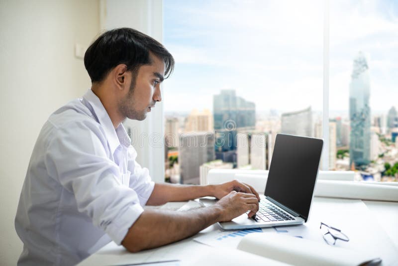 Επιχειρησιακό άτομο που εργάζεται με το lap-top και τα έγγραφα στοκ φωτογραφία με δικαίωμα ελεύθερης χρήσης Επιχειρησιακό άτομο που εργάζεται με το lap-top και τα έγγραφα στοκ φωτογραφία με δικαίωμα ελεύθερης χρήσης