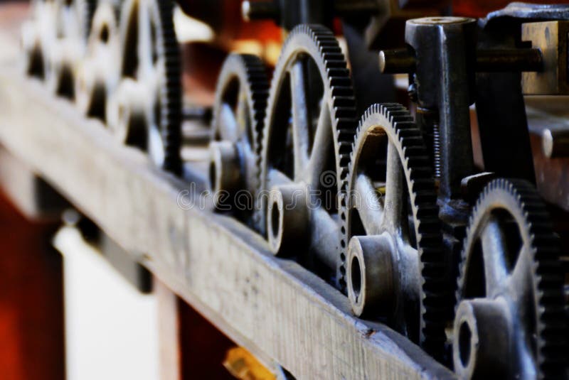 Close up of the gears on an old printing press. This machine reliably printed artwork and art notices over 100 years ago. With a little care and attention those cogs still work as smoothly as ever. Close up of the gears on an old printing press. This machine reliably printed artwork and art notices over 100 years ago. With a little care and attention those cogs still work as smoothly as ever