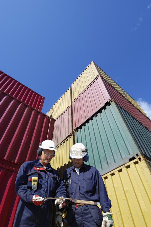 Port workers with stacks of cargo containers in background. Port workers with stacks of cargo containers in background