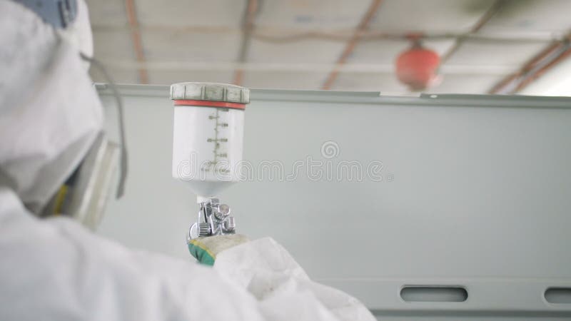 Εργαζόμενος άποψης πίσω πλευρών στο σώμα φορτηγών χρωμάτων μασκών με τον ψεκαστήρα απόθεμα βίντεο