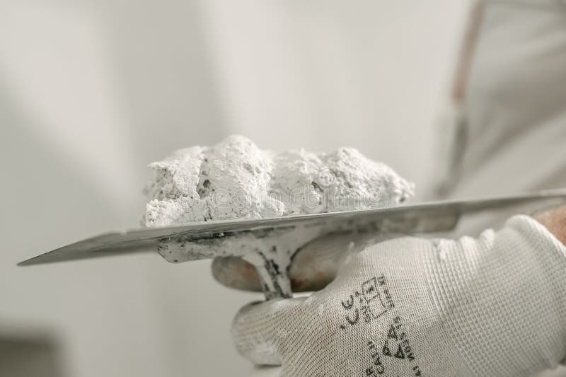 Εργαζόμενος κτιστών κατασκευής με spatula και το κονίαμα στοκ εικόνα Εργαζόμενος κτιστών κατασκευής με spatula και το κονίαμα στοκ εικόνα