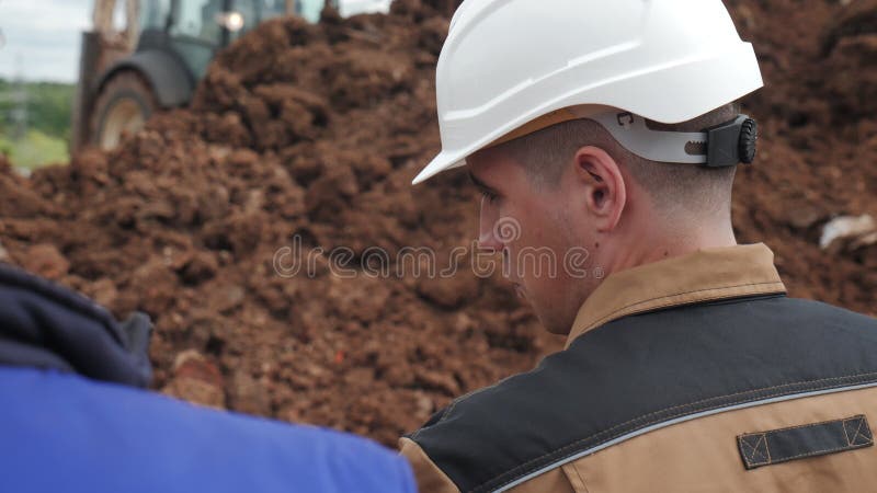 εργαζόμενος σε συνομιλίες με λευκό κράνος με συνάδελφο κοντά στο trento απόθεμα βίντεο