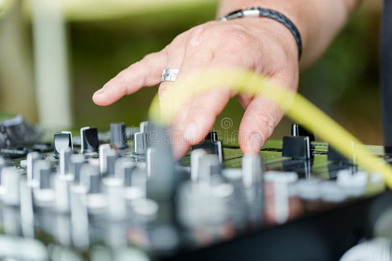 Εργασίες του DJ για την κονσόλα μιγμάτων στο υπαίθριο κόμμα στοκ φωτογραφία με δικαίωμα ελεύθερης χρήσης Εργασίες του DJ για την κονσόλα μιγμάτων στο υπαίθριο κόμμα στοκ φωτογραφία με δικαίωμα ελεύθερης χρήσης