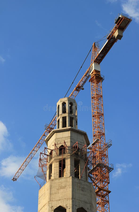 Construction site of mosque with tower crane and blue sky. Construction site of mosque with tower crane and blue sky