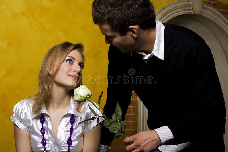 Young man is coming to date with his girlfriend with nice white rose. Young man is coming to date with his girlfriend with nice white rose.