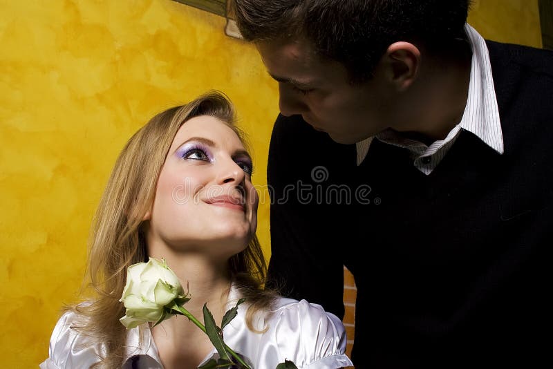 Young man is coming to date with his girlfriend with nice white rose. Young man is coming to date with his girlfriend with nice white rose.