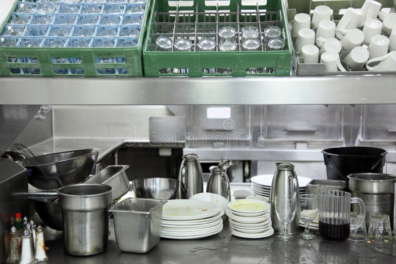 Resort hotel restaurant kiychen dishwasher area with dirty plates, cups and glassware. Resort hotel restaurant kiychen dishwasher area with dirty plates, cups and glassware