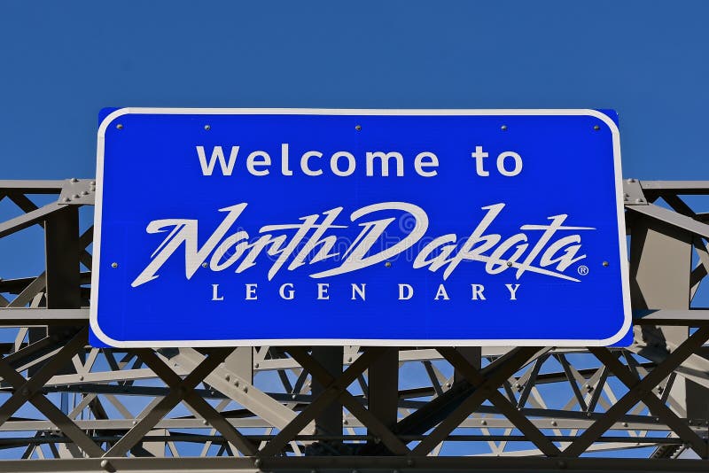 A `Welcome to North Dakota` sign is displayed over a bridge. A `Welcome to North Dakota` sign is displayed over a bridge.