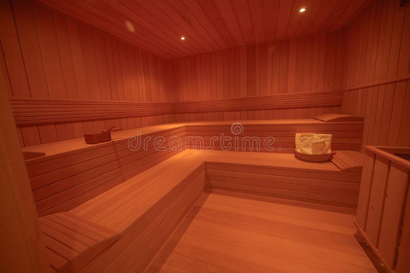 Finnish sauna interior view wide angle. Wooden sauna with light. SPA nobody. Steam room made from wood tree. Finnish sauna interior view wide angle. Wooden sauna with light. SPA nobody. Steam room made from wood tree