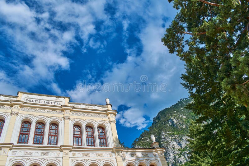 Wide angle view of Baile Herculane Casino with blue sky in background and an old tree outdoor day summer. Wide angle view of Baile Herculane Casino with blue sky in background and an old tree outdoor day summer