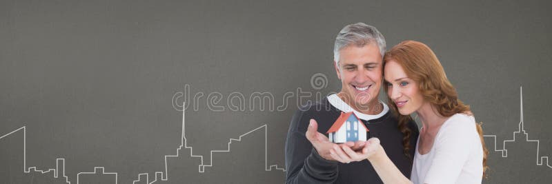 Ευτυχές ζεύγος που κρατά ένα σπίτι στο γκρίζο κλίμα ως έννοια της ασφάλειας στοκ εικόνες Ευτυχές ζεύγος που κρατά ένα σπίτι στο γκρίζο κλίμα ως έννοια της ασφάλειας στοκ εικόνες