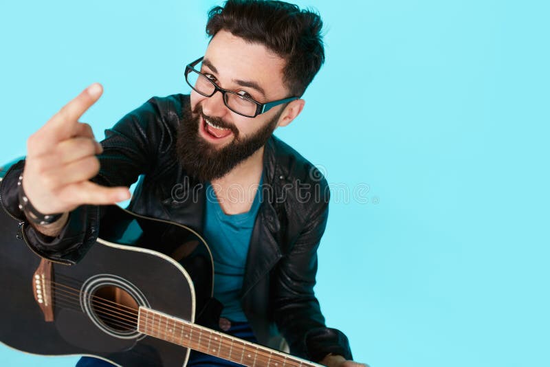 Ευτυχές νέο πανκ rocker με μια κιθάρα και σκοτεινά γυαλιά ηλίου στοκ φωτογραφίες Ευτυχές νέο πανκ rocker με μια κιθάρα και σκοτεινά γυαλιά ηλίου στοκ φωτογραφίες