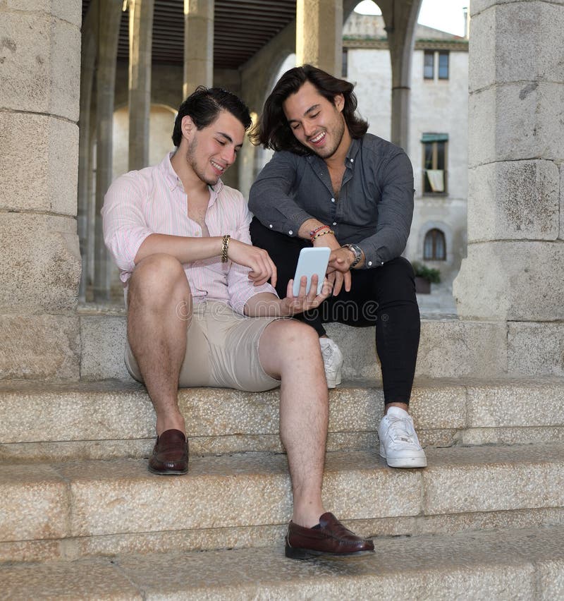 Ευτυχές ομοφυλοφιλικό ζεύγος με το κινητό τηλέφωνό τους στοκ εικόνες