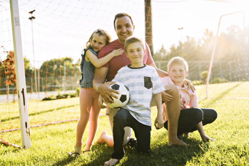 Ευτυχές ποδόσφαιρο παιχνιδιού οικογενειακού τρόπου ζωής έξω