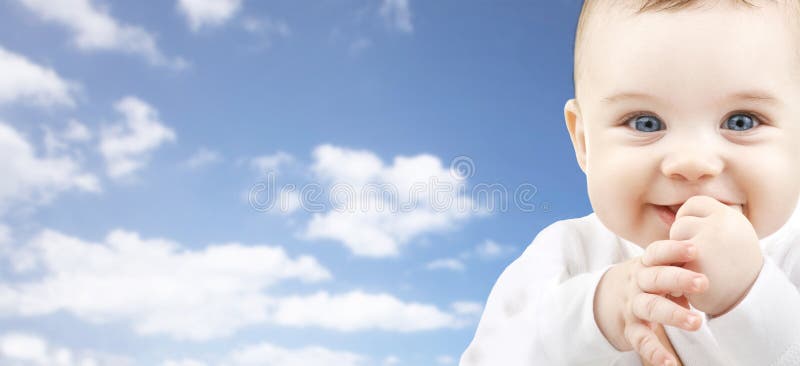 Ευτυχές πρόσωπο μωρών πέρα από το υπόβαθρο μπλε ουρανού
