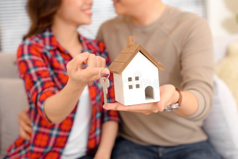 Ευτυχή κλειδιά εκμετάλλευσης ζευγών για τη νέα μικρογραφία σπιτιών και σπιτιών - πραγματική στοκ εικόνα με δικαίωμα ελεύθερης χρήσης Ευτυχή κλειδιά εκμετάλλευσης ζευγών για τη νέα μικρογραφία σπιτιών και σπιτιών - πραγματική στοκ εικόνα με δικαίωμα ελεύθερης χρήσης
