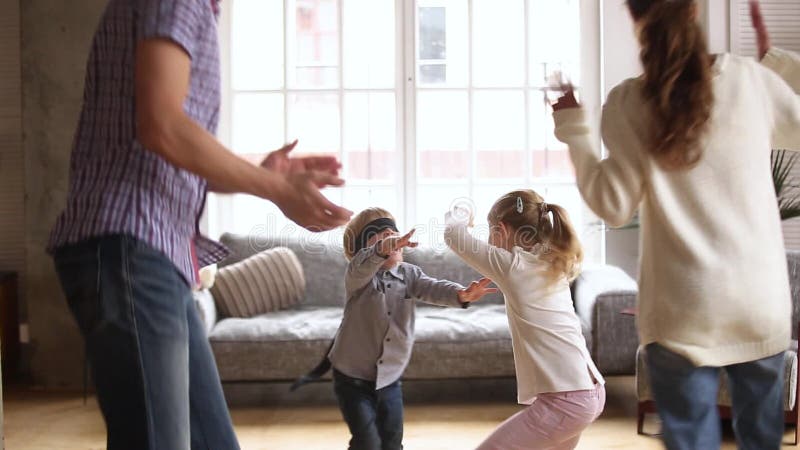 Ευτυχή οικογενειακά παιδιά που παίζουν τη δορά και το παιχνίδι χειροκροτήματος στο σπίτι