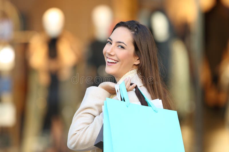 Ευτυχής αγοραστής που εξετάζει σας σε μια λεωφόρο στοκ φωτογραφία με δικαίωμα ελεύθερης χρήσης Ευτυχής αγοραστής που εξετάζει σας σε μια λεωφόρο στοκ φωτογραφία με δικαίωμα ελεύθερης χρήσης