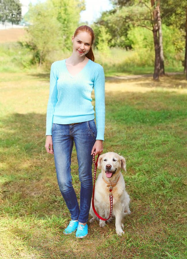Ευτυχής γυναίκα ιδιοκτητών και χρυσό Retriever σκυλί που περπατούν το καλοκαίρι στοκ εικόνα Ευτυχής γυναίκα ιδιοκτητών και χρυσό Retriever σκυλί που περπατούν το καλοκαίρι στοκ εικόνα
