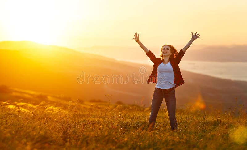 Ευτυχής γυναίκα στο ηλιοβασίλεμα στα ανοικτά χέρια φύσης iwith