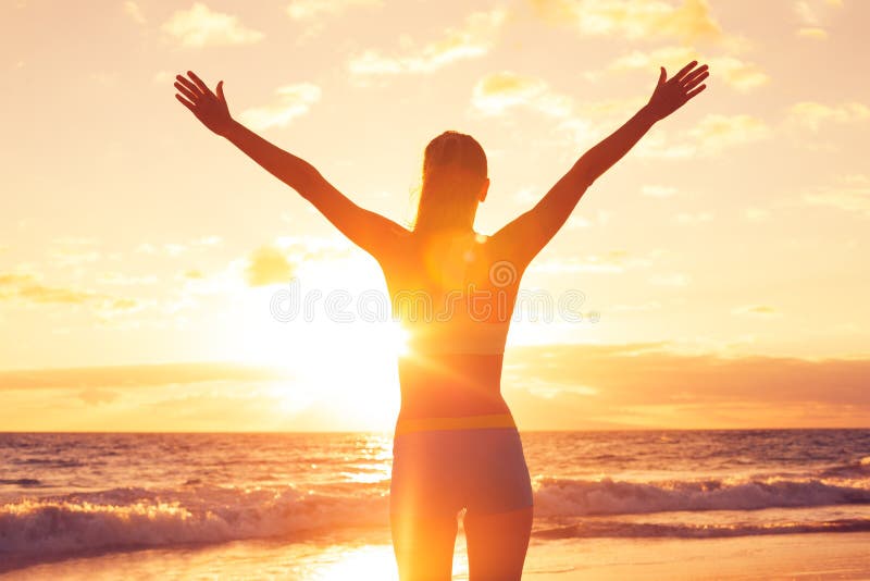 Ευτυχής ελεύθερη γυναίκα στο ηλιοβασίλεμα στην παραλία