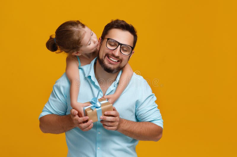 Ευτυχής ημέρα πατέρων ` s! χαριτωμένοι μπαμπάς και κόρη που αγκαλιάζουν στην κίτρινη πλάτη στοκ εικόνες Ευτυχής ημέρα πατέρων ` s! χαριτωμένοι μπαμπάς και κόρη που αγκαλιάζουν στην κίτρινη πλάτη στοκ εικόνες
