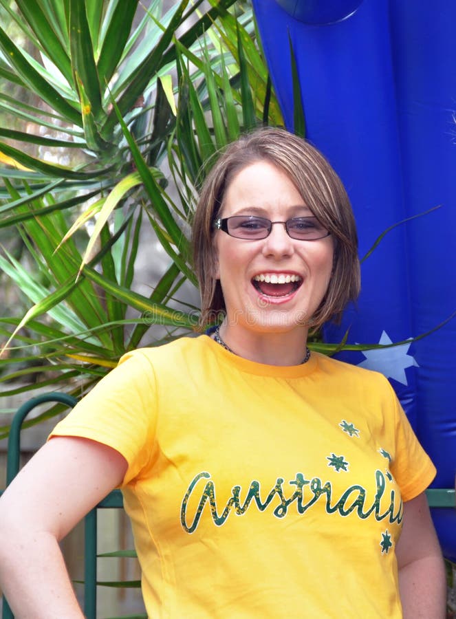 A beautiful young, proud and very patriotic Australian woman is outdoors on a sunny day in front of an inflatable flag of Australia with the widest most wonderful smile and expression as if she is shouting Happy Australia Day. The pretty young girl is wearing the colours of Australia in green and gold with Australia written across her t-shirt , celebrating Australia Day in style. A beautiful young, proud and very patriotic Australian woman is outdoors on a sunny day in front of an inflatable flag of Australia with the widest most wonderful smile and expression as if she is shouting Happy Australia Day. The pretty young girl is wearing the colours of Australia in green and gold with Australia written across her t-shirt , celebrating Australia Day in style.