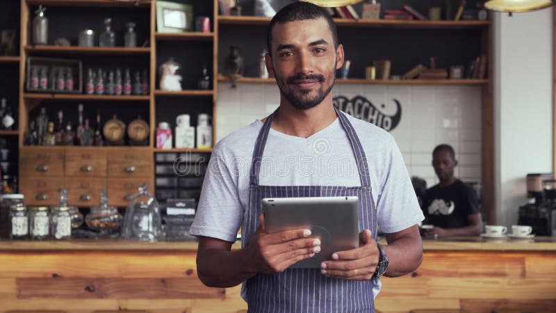Ευτυχής ιδιοκτήτης καφέδων που χρησιμοποιεί την ψηφιακή ταμπλέτα