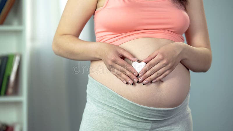 Ευτυχής κυρία που αναμένει το μωρό, που κρατά διαμορφωμένο το καρδιά αναμνηστικό στα χέρια, εγκυμοσύνη στοκ φωτογραφίες Ευτυχής κυρία που αναμένει το μωρό, που κρατά διαμορφωμένο το καρδιά αναμνηστικό στα χέρια, εγκυμοσύνη στοκ φωτογραφίες