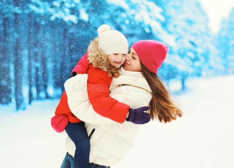 Ευτυχής κόρη μητέρων και παιδιών που έχει τη διασκέδαση μαζί το χειμώνα
