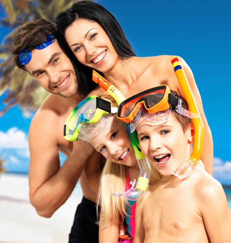 Portrait of happy fun beautiful family with two children at tropical beach with protective swimming mask. Portrait of happy fun beautiful family with two children at tropical beach with protective swimming mask