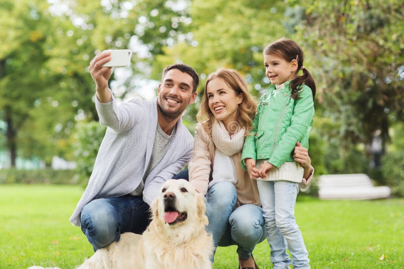 Ευτυχής οικογένεια με το σκυλί που παίρνει selfie από το smartphone στοκ εικόνα με δικαίωμα ελεύθερης χρήσης