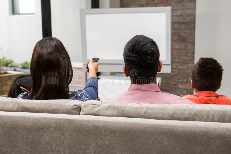 Ευτυχής οικογένεια που προσέχει τη TV στον καναπέ στοκ φωτογραφία με δικαίωμα ελεύθερης χρήσης Ευτυχής οικογένεια που προσέχει τη TV στον καναπέ στοκ φωτογραφία με δικαίωμα ελεύθερης χρήσης