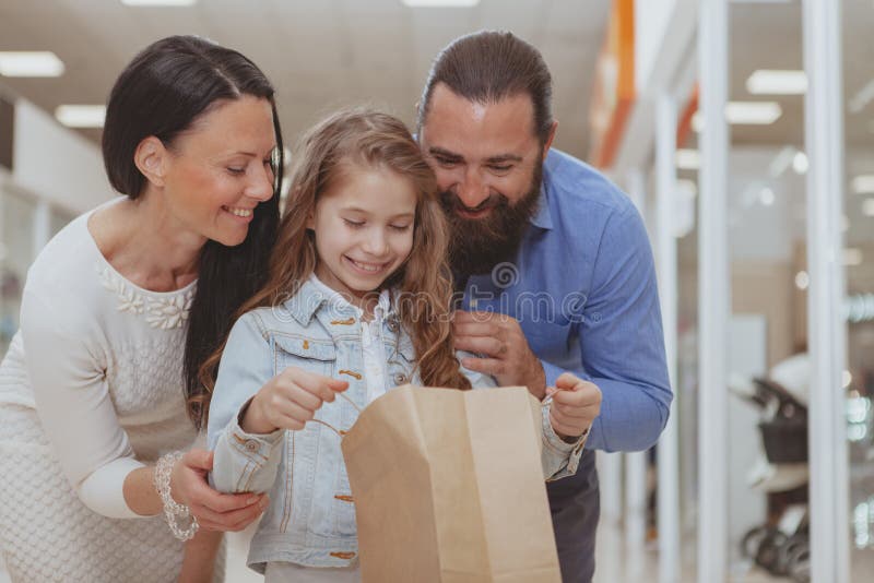 Ευτυχής οικογένεια που ψωνίζει στη λεωφόρο από κοινού στοκ φωτογραφία Ευτυχής οικογένεια που ψωνίζει στη λεωφόρο από κοινού στοκ φωτογραφία