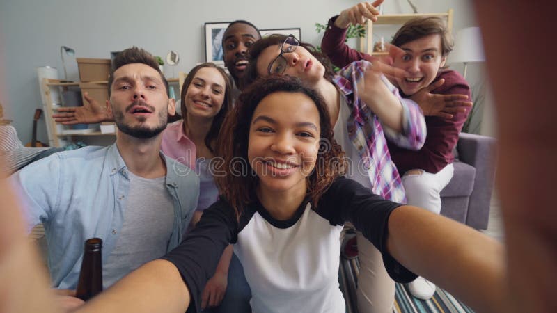 Ευτυχείς φίλοι που παίρνουν selfie στο σπίτι κρατώντας τη κάμερα που έχει τη διασκέδαση που εξετάζει τη κάμερα