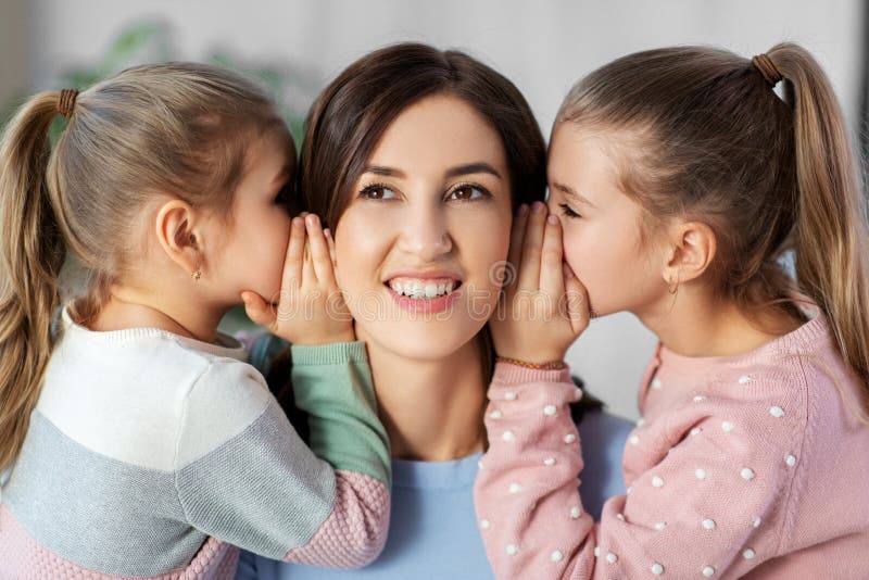 ευτυχισμένη μητέρα και κόρες που κουτσομπολεύουν στο σπίτι στοκ εικόνες