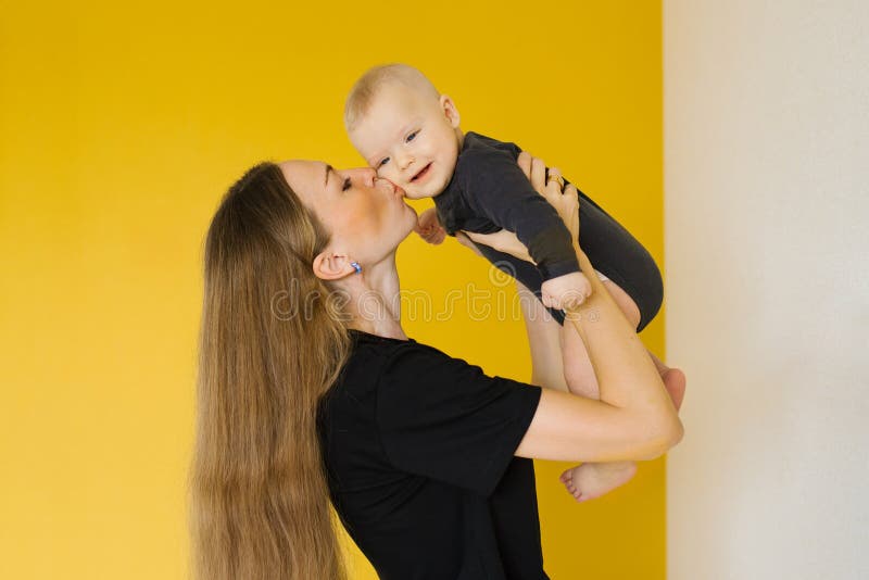ευτυχισμένη μητέρα κρατά μωρό στην αγκαλιά της. η σκηνή είναι ζεστή και στοργική στοκ εικόνες