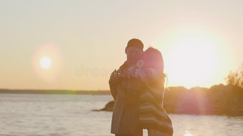 Ευτυχισμένο και ρομαντικό ζευγάρι που διασκεδάζει στην παραλία στο ηλιοβασίλεμα νεαρό ζευγάρι που περπατάει στην αμμώδη παραλία