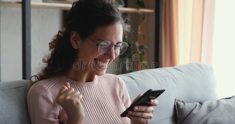 ευφορική νεαρή ελκυστική γυναίκα διαβάζει μηνύματα με καλά νέα.