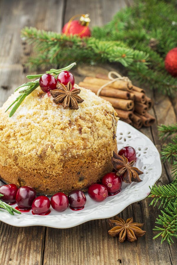 Fragrant homemade muffins with cranberries, candied fruits soaked in brandy, herbs and spices on a wooden dark background. Served with rosemary. selective focus. Fragrant homemade muffins with cranberries, candied fruits soaked in brandy, herbs and spices on a wooden dark background. Served with rosemary. selective focus