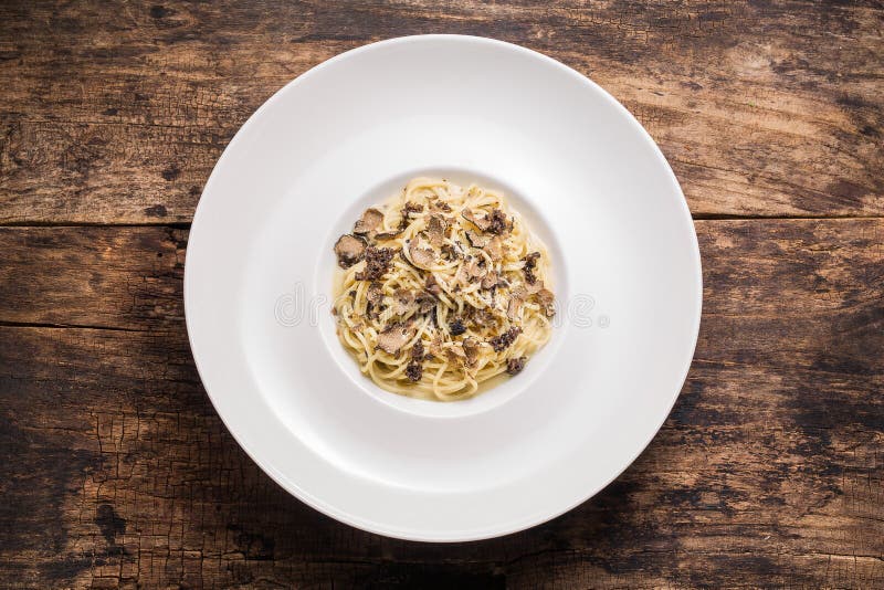 Εύγευστα ιταλικά ζυμαρικά με τις τρούφες Spagetti με τα μανιτάρια τρουφών στο ξύλινο εκλεκτής ποιότητας υπόβαθρο Τοπ όψη στοκ φωτογραφία Εύγευστα ιταλικά ζυμαρικά με τις τρούφες Spagetti με τα μανιτάρια τρουφών στο ξύλινο εκλεκτής ποιότητας υπόβαθρο Τοπ όψη στοκ φωτογραφία