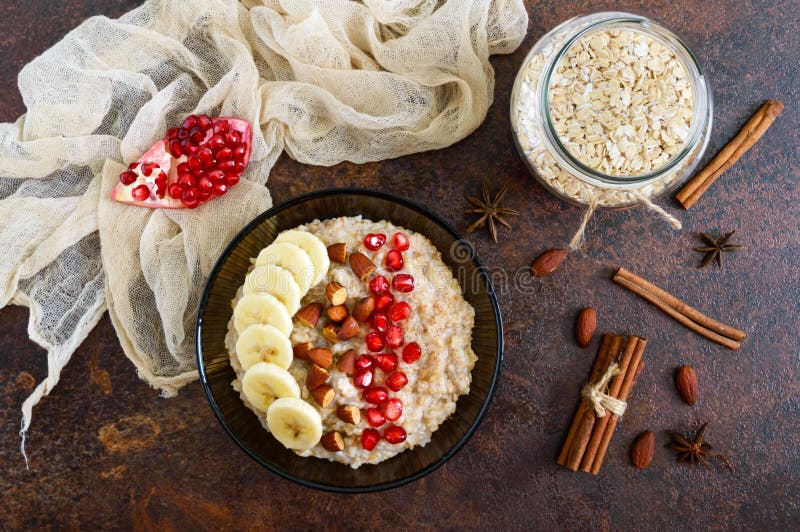Εύγευστο και υγιές oatmeal με την μπανάνα, τους σπόρους ροδιών, το αμύγδαλο και την κανέλα στοκ φωτογραφία Εύγευστο και υγιές oatmeal με την μπανάνα, τους σπόρους ροδιών, το αμύγδαλο και την κανέλα στοκ φωτογραφία