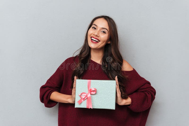 Εύθυμο κορίτσι brunette στο μοντέρνο πλεκτό δώρο β εκμετάλλευσης πουλόβερ στοκ εικόνες Εύθυμο κορίτσι brunette στο μοντέρνο πλεκτό δώρο β εκμετάλλευσης πουλόβερ στοκ εικόνες