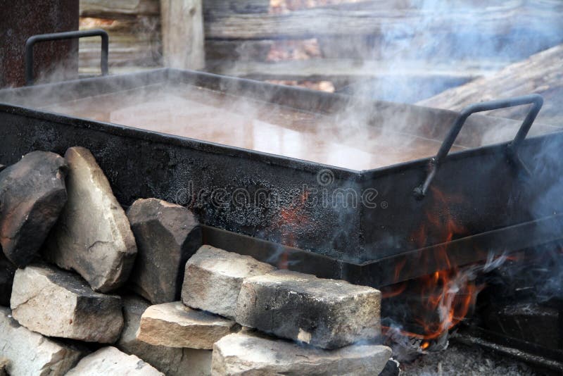 Traditional way of making maple syrup by boiling the sap in a pan. Traditional way of making maple syrup by boiling the sap in a pan