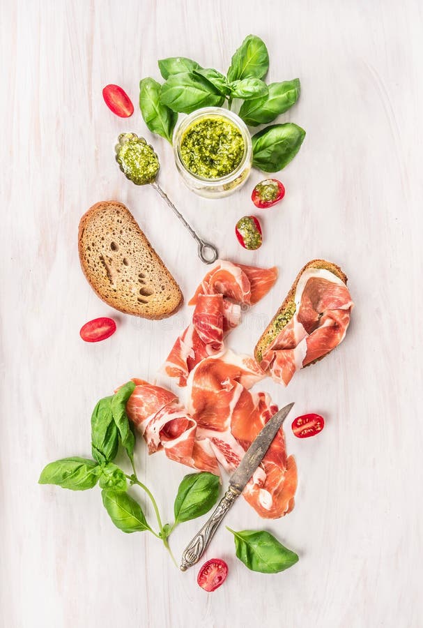 Ζαμπόν Prosciutto με το ψωμί φρυγανιάς, το pesto βασιλικού και τις ντομάτες στοκ φωτογραφία με δικαίωμα ελεύθερης χρήσης Ζαμπόν Prosciutto με το ψωμί φρυγανιάς, το pesto βασιλικού και τις ντομάτες στοκ φωτογραφία με δικαίωμα ελεύθερης χρήσης